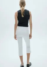 Jeans de tiro medio con diseño capri, confeccionados en tejido de algodón estilo tejano. Presentan cierre de cremallera y botón, trabillas para cinturón, cinco bolsillos y bajo con aberturas laterales.