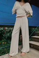 Pantalón palazzo de tiro medio en color marrón, confeccionado en tejido con textura. Cuenta con cintura elástica ajustable mediante cordones y diseño de pierna ancha.