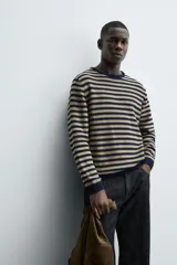 Jersey de punto con diseño de rayas horizontales en azul marino y beige, de corte regular fit. Presenta cuello redondo, manga larga y acabados en rib en cuello, puños y cintura. Confeccionado en tejido de algodón.