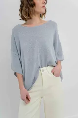 Sweater oversize de tejido liviano color blanco roto, con textura semi traslúcida, escote redondo y mangas amplias estilo murciélago.