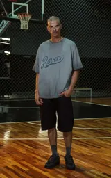 Remera de manga corta, cuello redondo y calce oversize, color gris oscuro con efecto batik/lavado. Estampado frontal con la palabra "Ravers" en tipografía cursiva estilo universitario en tono azul oscuro.