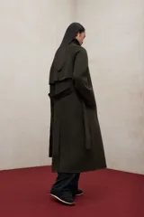 Abrigo largo de lana reciclada en color verde oscuro, con diseño de corte recto, mangas raglán, cuello alto con cierre de botones y cinturón ajustable a la cintura.