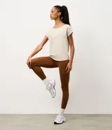 Remera deportiva de microfibra texturizada, color blanco, con cuello redondo, mangas cortas y recortes laterales.