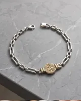 Pulsera de eslabones de plata con medalla central dorada con relieve del Espíritu Santo.
