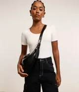 Bolso grande tipo hobo de material sintético negro, con correa de hombro ajustable y cierre de cremallera.
