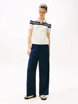 Chomba blanca de piqué de algodón elástico con rayas horizontales azul marino en cuello y mangas, corte slim, cuello de chomba con tapeta de seis botones y logo de Tommy Hilfiger bordado en la manga.