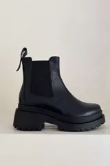 Botas Chelsea negras de cuero con plataforma track y elásticos laterales.