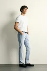 Jeans slim fit de tiro medio, color celeste claro con efecto lavado. Confeccionados en tejido elástico, cuentan con diseño de cinco bolsillos y cierre frontal con cremallera y botón metálico.