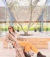 Tapado largo de paño liviano con diseño de cuadros en tonos marrones. Presenta solapas clásicas, bolsillos laterales con detalles en cuero y tajos profundos en los costados.