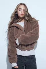 Campera de piel sintética color marrón, con cierre frontal, cuello alto y diseño holgado.