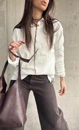 Sweater de hilo color blanco con cuello redondo y diseño de bordados florales en relieve en el frente.