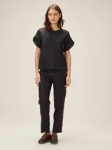 Blusa de lino color crudo, con cuello redondo y mangas cortas adornadas con volados dobles.