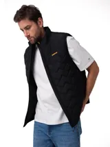 Chaleco acolchado negro con diseño de costuras geométricas, cierre frontal con cremallera y logo de la marca bordado en amarillo en el pecho.