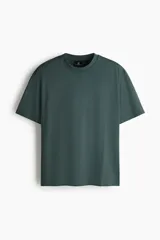 Remera verde oscuro de corte relajado, confeccionada en punto de algodón de peso medio, con cuello redondo ribeteado y hombros caídos.