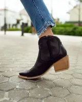 Bota texana de caña baja color marrón con efecto vintage, confeccionada en cuero vacuno y forrada en cuero. Tiene taco de 5cm y cierre lateral.