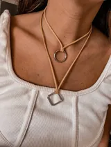 Collar doble con cadena de cuero sintético negro y dije rectangular plateado.