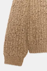 Sweater de punto con cinta entrelazada, color tostado, escote redondo pronunciado y manga larga con puños ajustados.