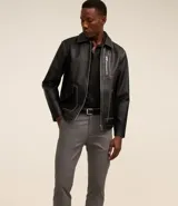 Pantalón slim color tostado, confeccionado en sarga, con cierre de botón y cremallera, y bolsillos tipo cuchillo.