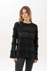 Blusa negra plisada de manga larga con detalles de volados horizontales en el frente y las mangas.