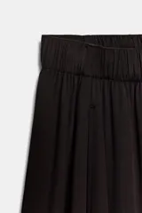 Pantalón fluido de tiro bajo con cintura elástica, confeccionado en tejido ligero con caída, de corte amplio y diseño minimalista.