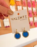 Aros colgantes con aro de acero dorado y dije circular azul con borde de strass.