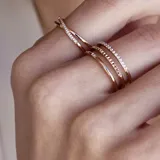 Anillo triple color oro rosa de acero con cristales incrustados de circonita cúbica.