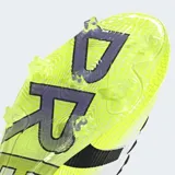 Championes de fútbol Adidas Predator Pro para terreno firme (FG), color blanco con tres franjas negras y puntera en color amarillo neón. Presentan la inscripción "PREDATOR EST. 1994" en el talón y suela con tapones transparentes.