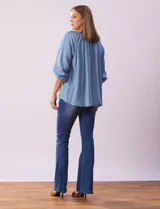 Blusa celeste de tencel con cuello redondo, escote en V y lazo de ajuste. Tiene cuello y escote calado y mangas 3/4 amplias con puño elastizado.