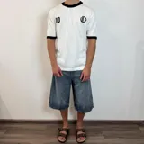 Remera tejida blanca con cuello y puños negros, con el número 10 estampado en la espalda en color negro. Incluye las siglas VCP y el rango de años 2015-infinito.