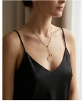 Collar de acero con baño de oro, con diseño de cadena ajustable y dos dijes colgantes: un círculo calado con textura y un aro liso.