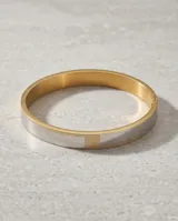 Pulsera tipo esclava rígida de acero inoxidable con baño de oro, que presenta un diseño bicolor con secciones lisas y una sección central texturizada.