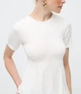 Blusa de manga corta con cuello redondo y diseño peplum, confeccionada en viscosa con recortes estructurados que definen la cintura y aportan movimiento al ruedo.