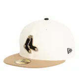 Gorra de visera plana New Era modelo 59Fifty, con cuerpo color crema y visera color tostado. Presenta el logo de los Boston Red Sox bordado en el frente en colores negro y tostado, y el logo de la marca en el lateral.