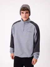 Gorro tipo beanie de punto en color gris, con franjas horizontales en verde y blanco, y logo de la marca Rusty en el frente.