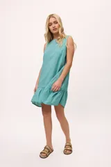 Vestido corto de corte holgado, color turquesa, con escote bote y detalle de volado en el ruedo.