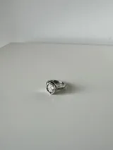 Anillo de acero quirúrgico dorado con diseño orgánico y piedra cristal transparente facetada en el centro.