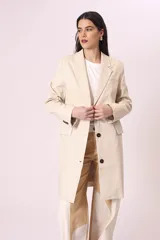 Blazer largo color beige, de corte recto y solapas clásicas.