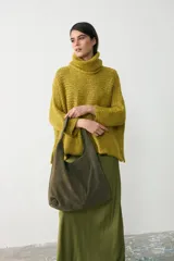 Cartera tipo tote de gran capacidad, confeccionada en cuero agamuzado color verde seco. Presenta un diseño minimalista con asa única ancha integrada para llevar al hombro.
