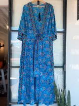 Kimono largo con estampado de cachemir en tonos azul, naranja y rosa. Tiene corte cruzado, mangas anchas y largo hasta los tobillos.