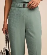 Pantalón recto color verde agua, de jacquard texturizado, con cinturón elástico con hebilla y cierre lateral.