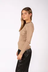 Sweater negro de tejido de punto acanalado, con ajuste al cuerpo, mangas largas y detalle de abertura tipo gota en el escote.