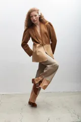 Blazer sastrero bicolor que combina lana marrón en la parte superior y cuero sintético beige en la inferior, con solapa chal y cierre frontal con botón.