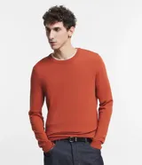 Suéter de punto color ladrillo, de corte clásico, con cuello redondo y mangas largas.