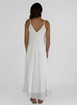 Vestido largo blanco de tirantes finos, con escote en V profundo y detalle de volados en el frente. Diseño fluido y ligero.