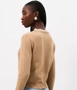 Cardigan de punto marrón de manga larga, con cierre frontal de botones y detalles de encaje blanco en el cuello redondo y los puños.