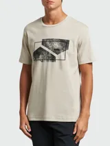 Camiseta de manga corta y cuello redondo, color beige claro, con un estampado gráfico frontal en negro que simula un diseño abstracto y texturizado dentro de un recuadro.