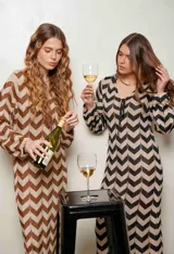 Vestido largo de lurex con diseño de patrón en zigzag en tonos tostado y marrón, escote en V con cordones para atar y mangas largas.