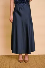 Pollera evasé midi de satén color azul marino, de tiro alto y caída fluida.