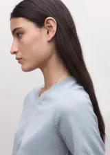 Chaleco de lana 100% en color celeste con cuello en V, de diseño clásico y versátil.