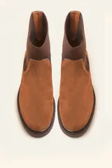 Bota tipo chelsea de gamuza color marrón, con paneles laterales elásticos acanalados y suela de goma track con taco bajo.